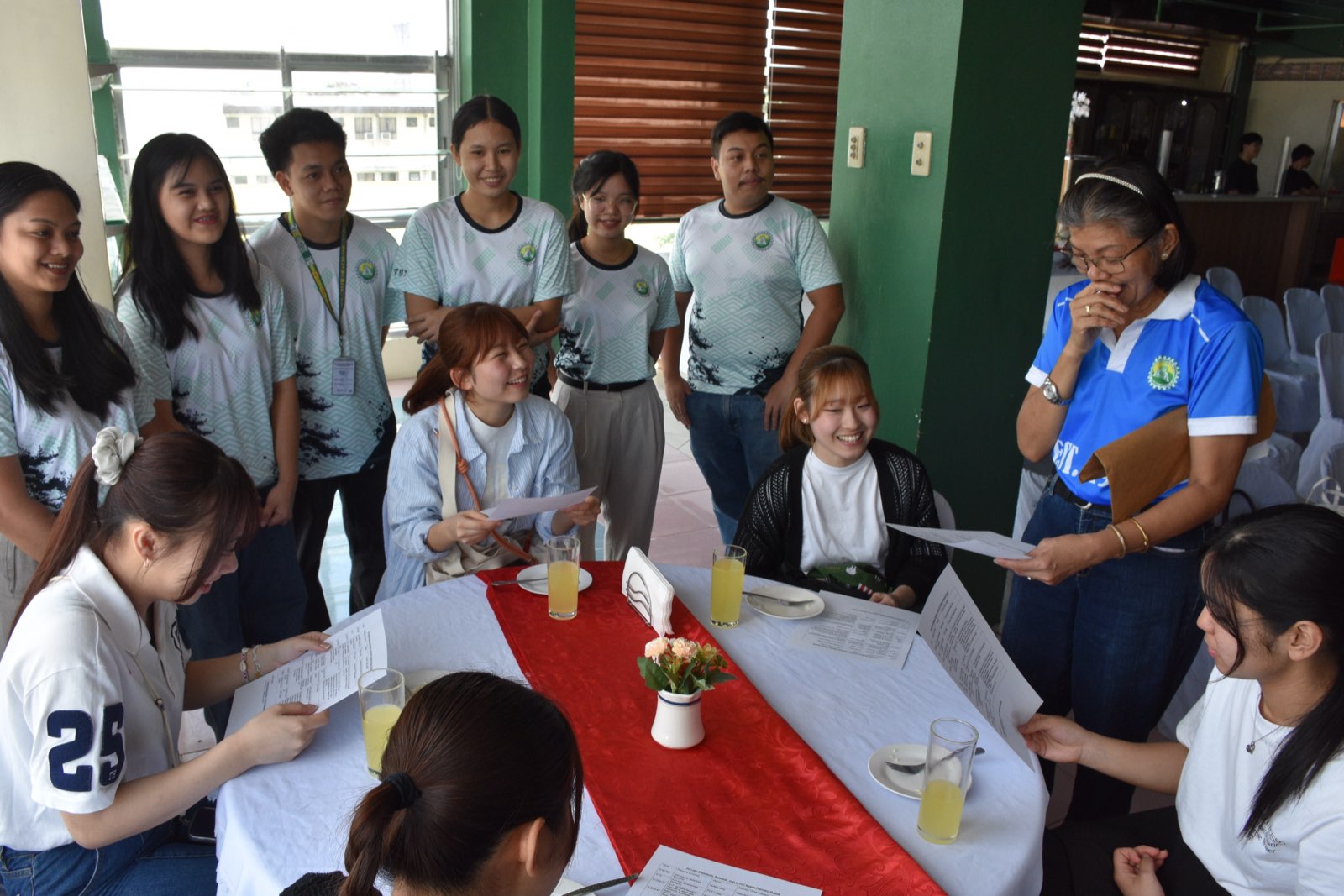 Students and their teacher gathered around a table in the PCT Japanese Language Program classroom